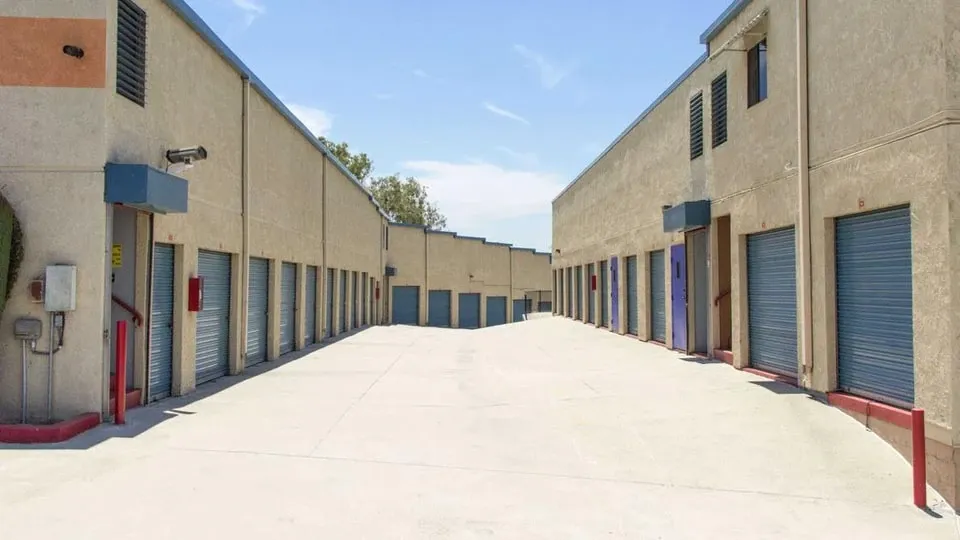 Long row of large outdoor storage units with blue doors