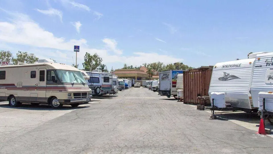 A large parking lot area with RVs, trailers, and trucks parked next to each other